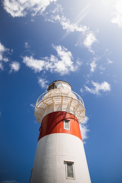 Red and white lighthouse under the blue sky during the day
